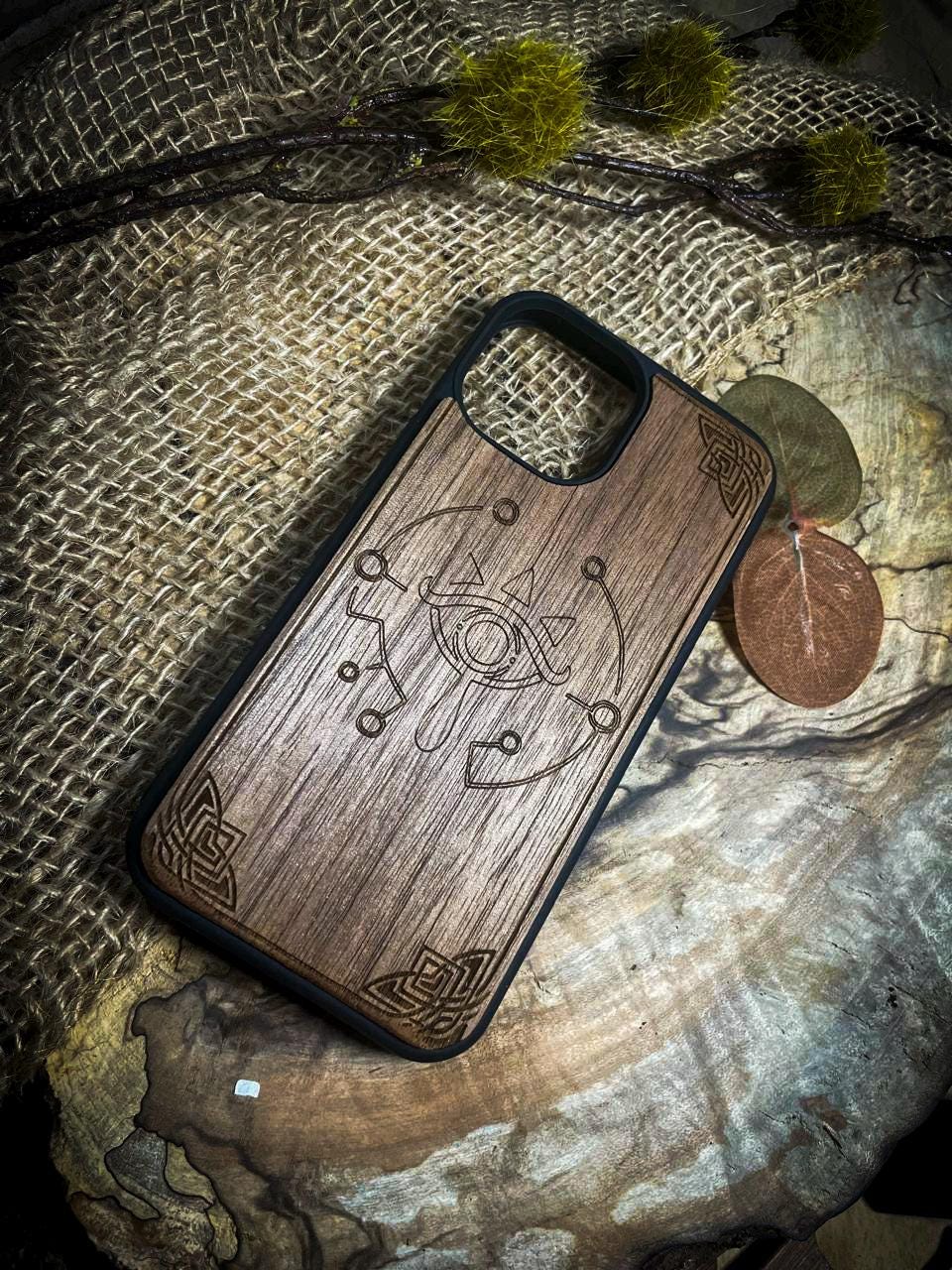 a wooden phone case sitting on top of a tree stump